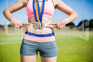 Mid section of female athlete with gold medals around her neck