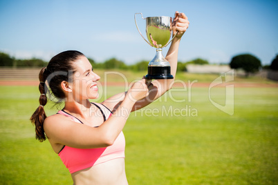 Happy female athlete showing her trophy