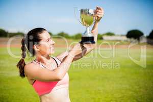 Happy female athlete showing her trophy