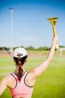 Rear view of female athlete holding a fire torch