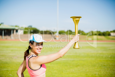 Happy female athlete holding a fire torch