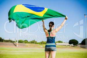 Rear view of female athlete holding an brazil flag