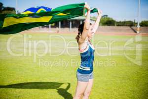 Female athlete holding an Brazilian flag