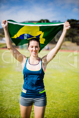 Female athlete holding an Brazilian flag