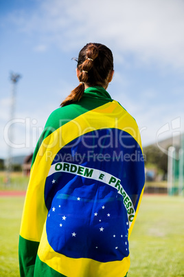 Female athlete wrapped in Brazilian flag