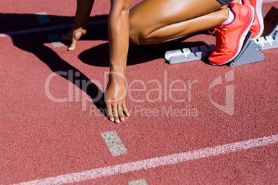 Female athlete ready to run on running track