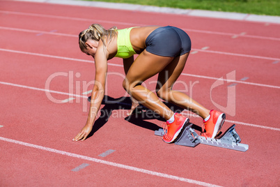 Female athlete ready to run on running track