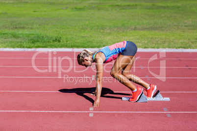 Female athlete ready to run on running track