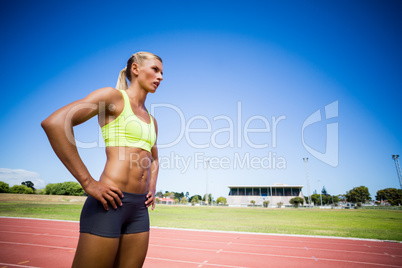 Confident female athlete standing with hand on hip