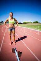 Confident female athlete standing with hand on hip