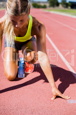 Female athlete ready to run on running track