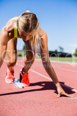 Female athlete ready to run on running track