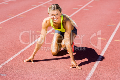 Female athlete ready to run on running track