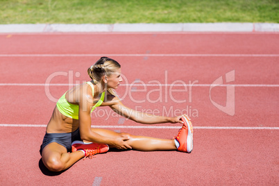 Female athlete warming up on the running track