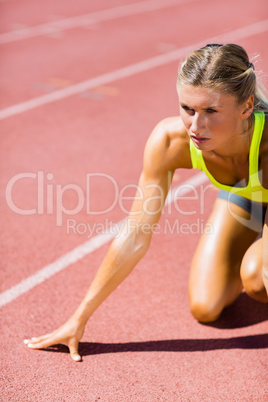 Female athlete ready to run on running track