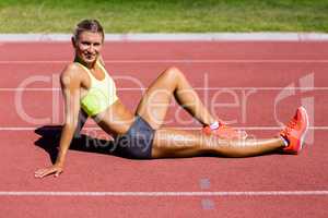 Female athlete sitting on the running track