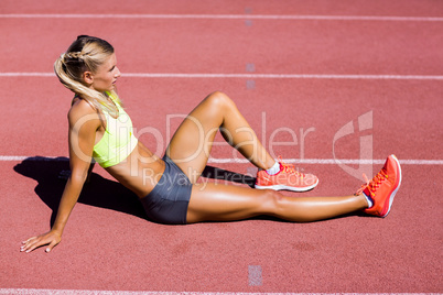 Female athlete sitting on the running track Female athlete sitting on the running track