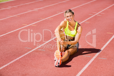 Female athlete sitting on the running track