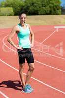 Portrait of female athlete standing with hands on hi