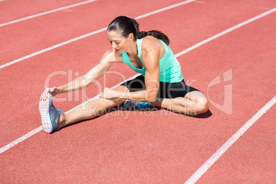 Female athlete stretching her hamstring