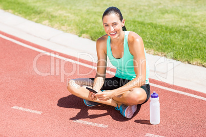 Portrait of happy female athlete using mobile phon