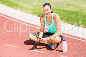 Portrait of happy female athlete using mobile phon