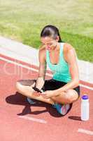 Happy female athlete using mobile phone