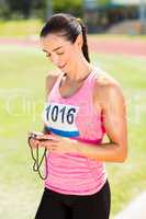 Happy female athlete using stopwatch