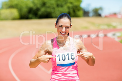 Portrait of female athlete pointing at badge
