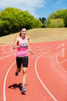 Female athlete running on the running track