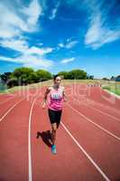 Female athlete running on the running track