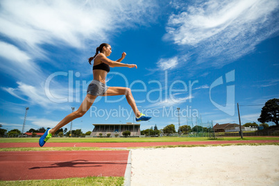 Female athlete performing a long jump