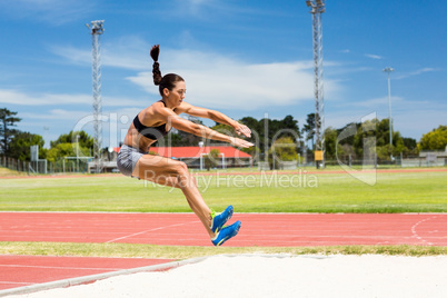 Female athlete performing a long jump