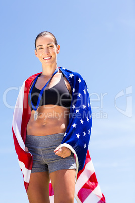 Portrait of female athlete wrapped in american flag