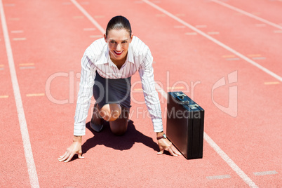 Portrait of happy businesswoman with briefcase in ready to run p