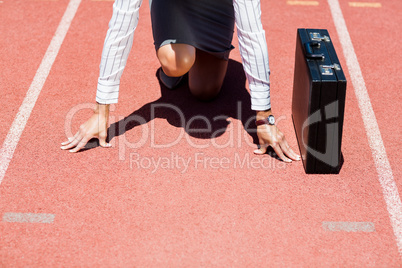 Businesswoman with briefcase in ready to run position