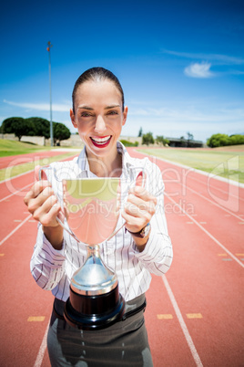 Portrait of happy businesswoman holding a trophy