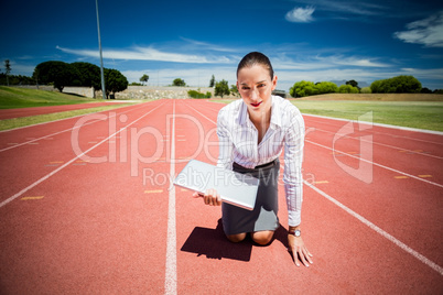 Businesswoman ready to run with a laptop