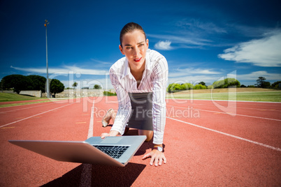 Businesswoman ready to run with a laptop
