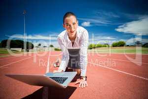 Businesswoman ready to run with a laptop