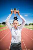 Portrait of happy businesswoman holding a trophy over her head