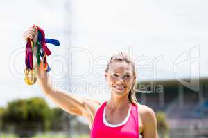 Portrait of female athlete showing her gold medals