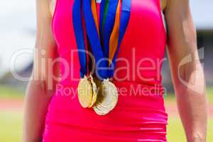 Mid section of female athlete with gold medals