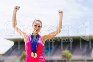 Excited female athlete with gold medals around her neck