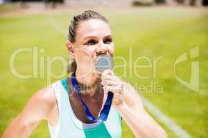 Female athlete kissing his gold medal