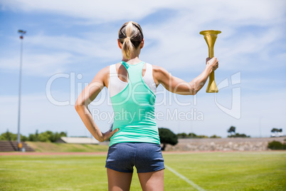 Rear view of female athlete holding a fire torch