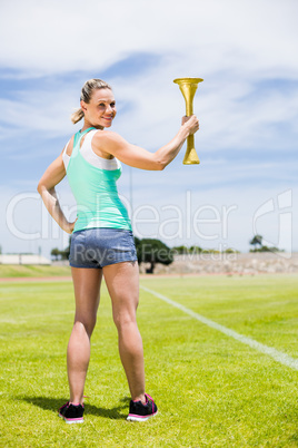 Portrait of happy female athlete holding a fire torch