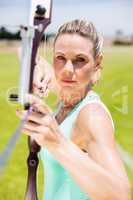 Confident female athlete practicing archery