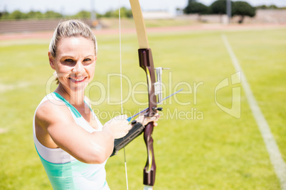 Portrait of female athlete practicing archery