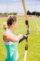 Happy female athlete practicing archery